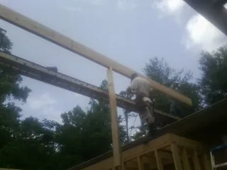 Carpenter setting a ridge beam over a new addition frame — Ice Dam Removal by Roofing Brothers in East Schodack