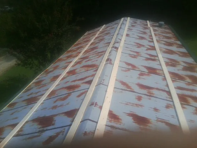 Rusted metal roof panels with new wood purlins before replacement — Storm Damage Roof Repair in East Schodack by Roofing Brothers