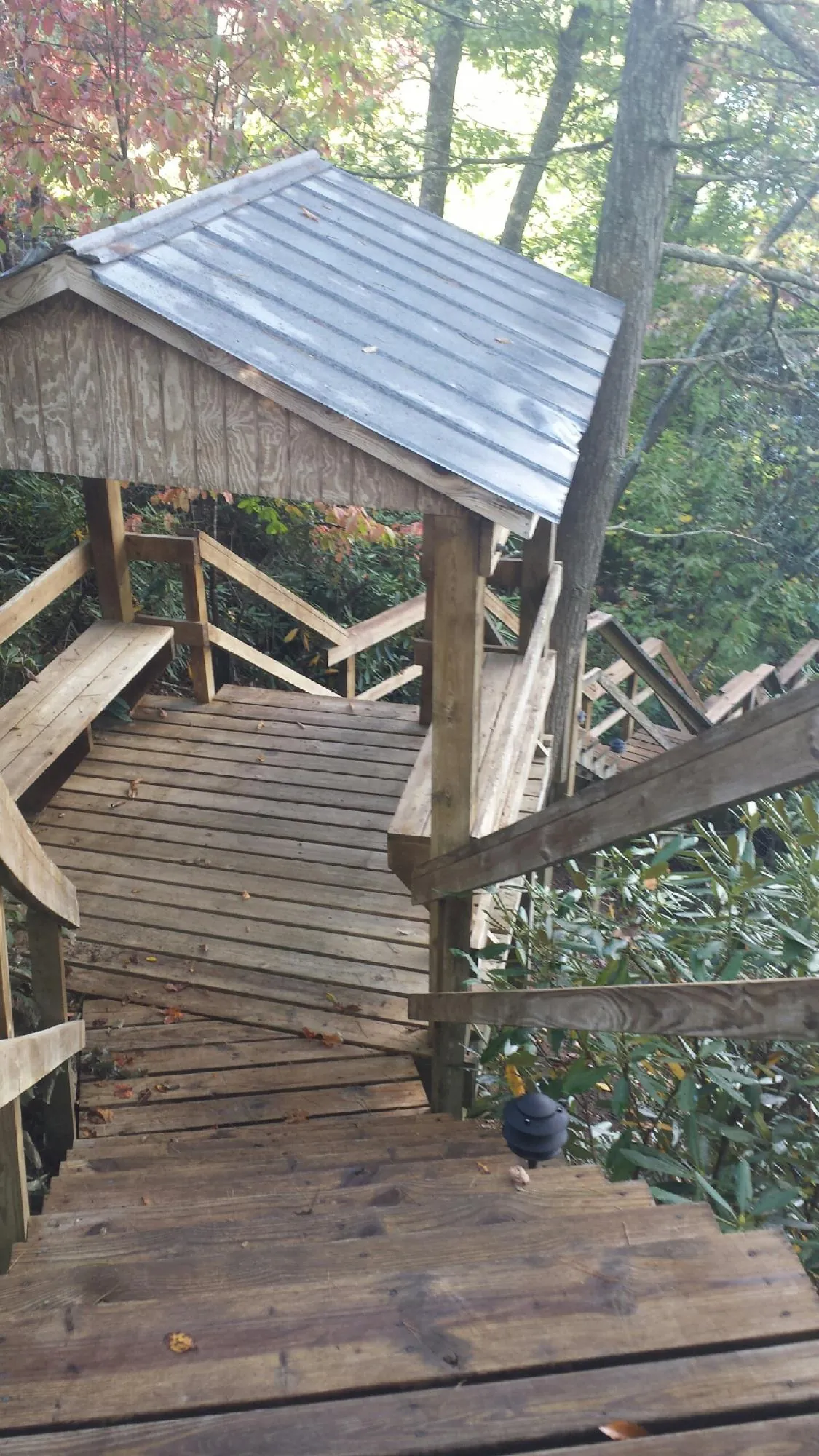 Metal roofed shelter over wooden steps on a wooded walkway — Skylight Repair & Installation work by our crew in East Schodack